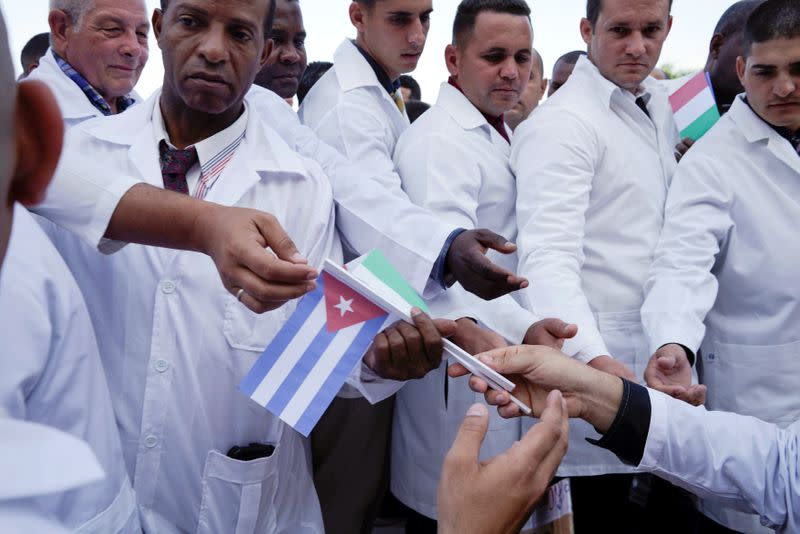 Cuban doctors receive Cuban and Italian flags during a farewell ceremony before departing to Italy to assist, amid concerns about the spread of the coronavirus disease outbreak, in Havana