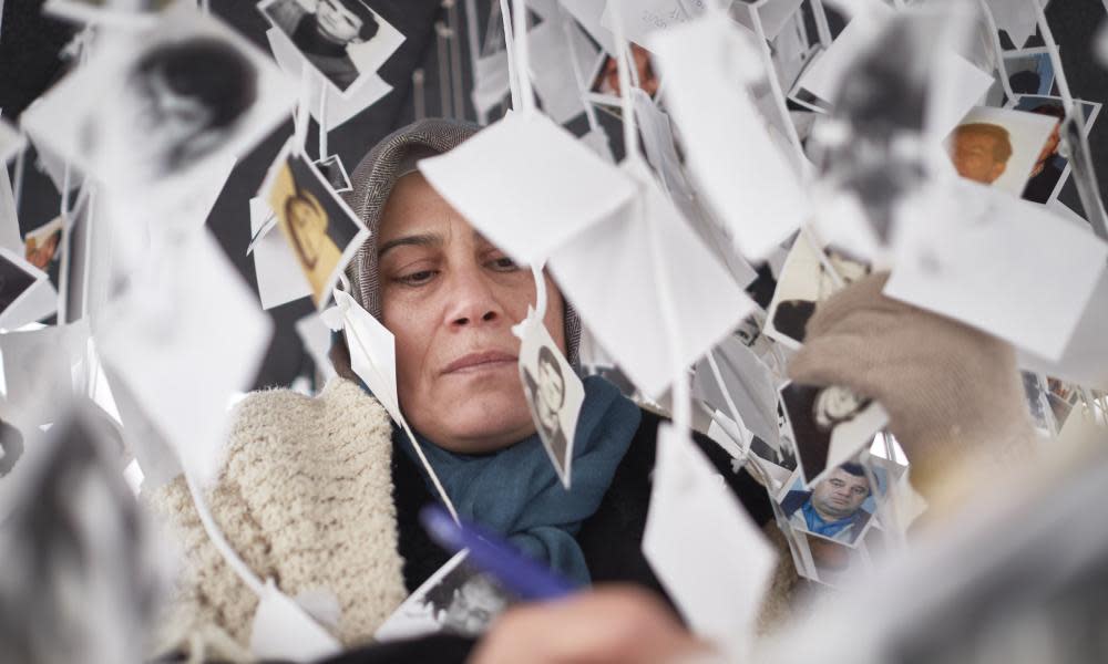 A woman signs a book in a makeshift memorial for Bosnian Muslim victims of war crimes on 22 November 2017 in The Hague, the Netherlands