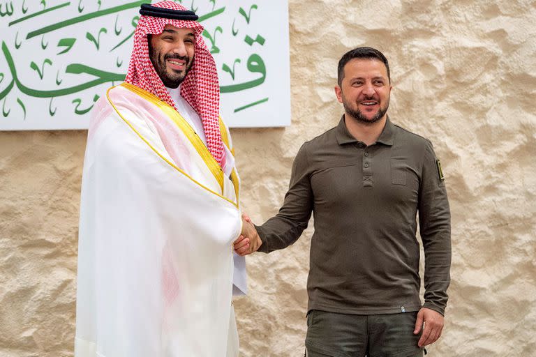 En esta imagen facilitada por el Palacio Real saudita el 19 de mayo de 2023 se ve al príncipe heredero, Mohamed Ben Salman, estrechando la mano del presidente de Ucrania, Volodimir Zelensky, antes de la reunión de la Cumbre Árabe en Yeda.