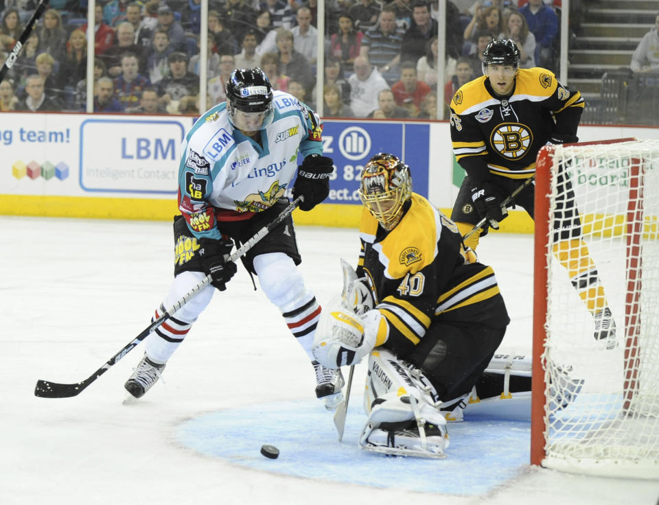 FILE - Spectators watch Belfast Giants Selects, Tim Cook, left in action against Boston Bruins, Kutta Rask foreground during the pre-season NHL hockey game in Belfast, Northern Ireland, Saturday, Oct. 2, 2010. "Import” hockey players in the United Kingdom don't earn big salaries but the lifestyle and perks are pretty good. They get free use of a car and rent-free housing. These mostly Canadian and American imports are mini-celebrities around the Elite Ice Hockey League. They can also earn a master's degree tuition-free. Adam Johnson of the Nottingham Panthers was living with his fiancée and studying at a business school. (AP Photo, File)