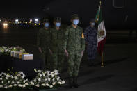Mexican soldiers mourn five boxed cremated remains, of Mexicans who died from COVID-19, during a welcoming ceremony at the tarmac of Benito Suarez International airport in Mexico City, Saturday, July 11, 2020. The ashes of 245 Mexican were repatriated to Mexico from New York in a military airplane. (AP Photo/Fernando Llano)