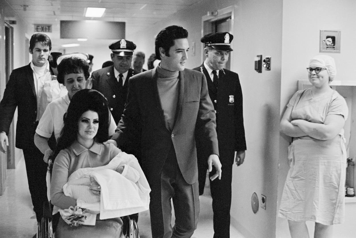 (Original Caption) 2/7/1968-Memphis, TN: Evis Presley with his wife and daughter as they leave Baptist Hospital.