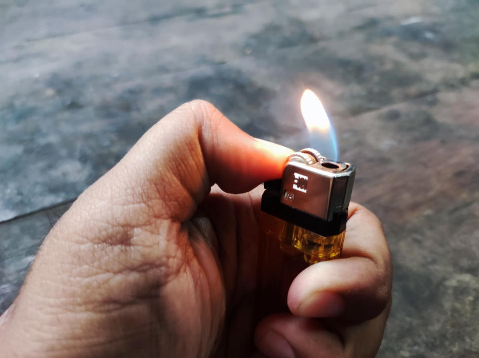 hand holding a lit lighter