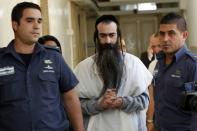 Yishai Shlissel (centre), suspected of stabbing six Gay Pride marchers the previous day, is brought handcuffed to court in Jerusalem on July 31, 2015