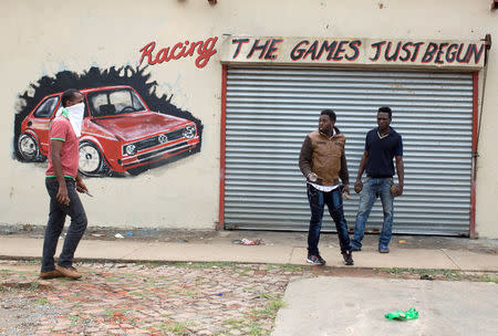 Immigrants hold rocks and a knife during clashes in Pretoria, South Africa, February 24, 2017. Police fired tear gas, water cannon and rubber bullets to disperse rival marches by hundreds of protesters in Pretoria on Friday, after mobs looted stores this week believed to belong to immigrants. REUTERS/ James Oatway