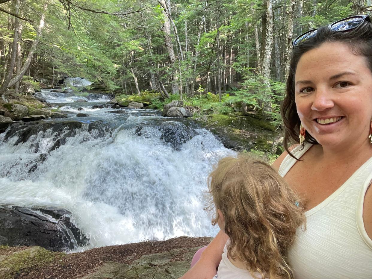 Woman and child posing for photo next to river