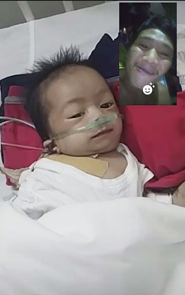 This photo provided by Ronnel Manjares shows Kobe Christ Manjares during a video call with him, upper right, at a hospital in metropolitan Manila, Philippines, Tuesday, June 2, 2020. Manjares' 16-day-old son Kobe was heralded as the country's youngest COVID-19 survivor. But the relief and joy proved didn't last. Three days later, Kobe died on June 4 from complications of Hirschsprung disease, a rare birth defect. (Ronnel Manjares via AP)