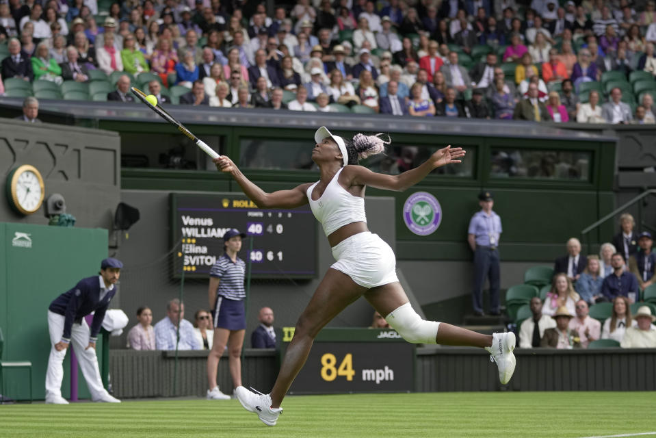 Venus Williams of the US run back to return a lob to Ukraine's Elina Svitolina in a first round women's singles match on day one of the Wimbledon tennis championships in London, Monday, July 3, 2023. (AP Photo/Kin Cheung)