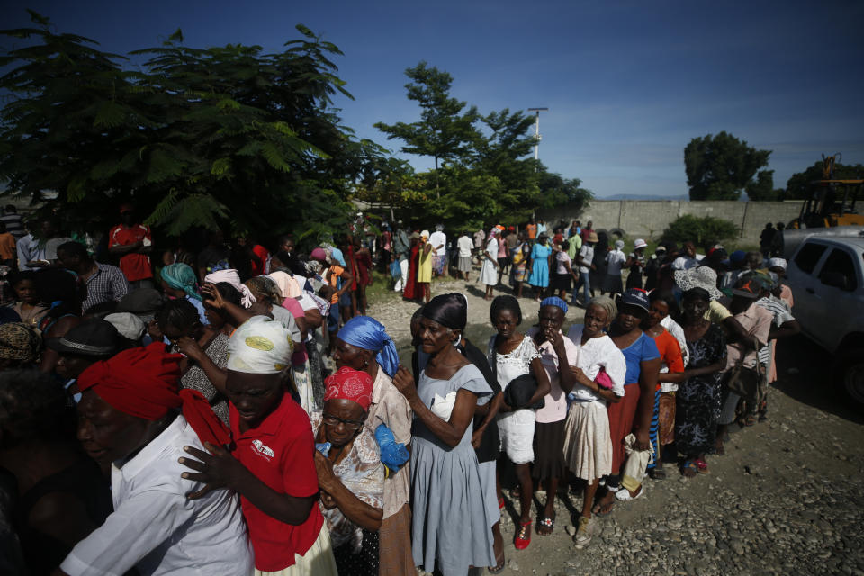 Women line up in hopes of receiving a meal of beans and rice during a federal government distribution of food and school supplies to some residents of Cite Soleil, in Port-au-Prince, Haiti, Thursday, Oct. 3, 2019. The daily struggles of Haitians have only become more acute as recent anti-government protests and roadblocks force the closure of businesses, sometimes permanently, as people lose jobs and dwindling incomes fall behind a spike in prices. (AP Photo/Rebecca Blackwell)