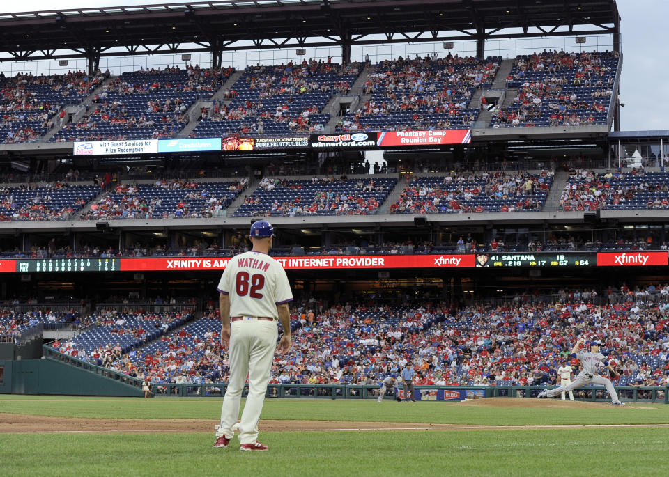 New York Mets' Jacob deGrom, right, throws in the ninth inning of a baseball game as Philadelphia Phillies third base coach Dusty Wathan watches, Saturday, Aug. 18, 2018, in Philadelphia. The Mets won 3-1. (AP Photo/Michael Perez)