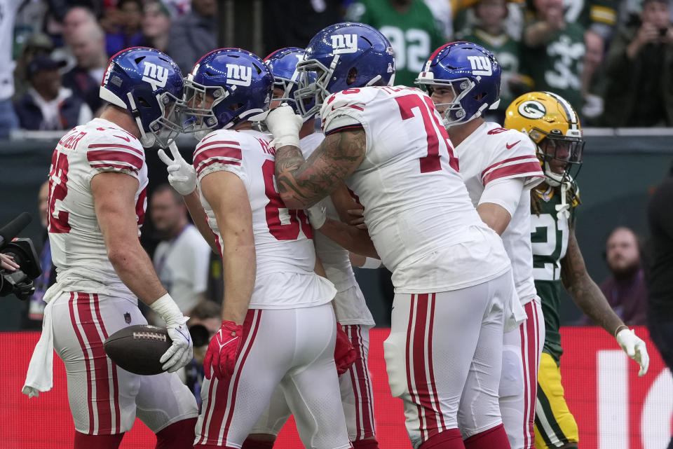 New York Giants tight end Daniel Bellinger (82), left, celebrates with team-mates after scoring a touchdown during an NFL game between the New York Giants and the Green Bay Packers at the Tottenham Hotspur stadium in London, Sunday, Oct. 9, 2022. (AP Photo/Kin Cheung)