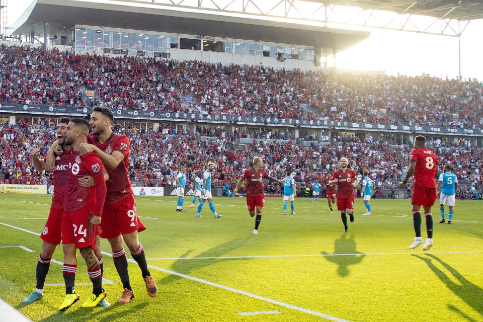 Toronto FC midfielder Jonathan Osorio, left, celebrates with teammates Lorenzo Insigne (24) and forward Jesús Jiménez (9) after scoring the first goal of an MLS soccer match against Charlotte FC against during the first half in Toronto, Saturday July 23, 2022. (Chris Young/The Canadian Press via AP)
