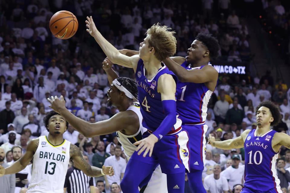 Kansas guards Gradey Dick (4) and Joseph Yesufu (1), along with Baylor forward Flo Thamba, second from left, reach for the ball during the second half of a game Monday in Waco, Texas.