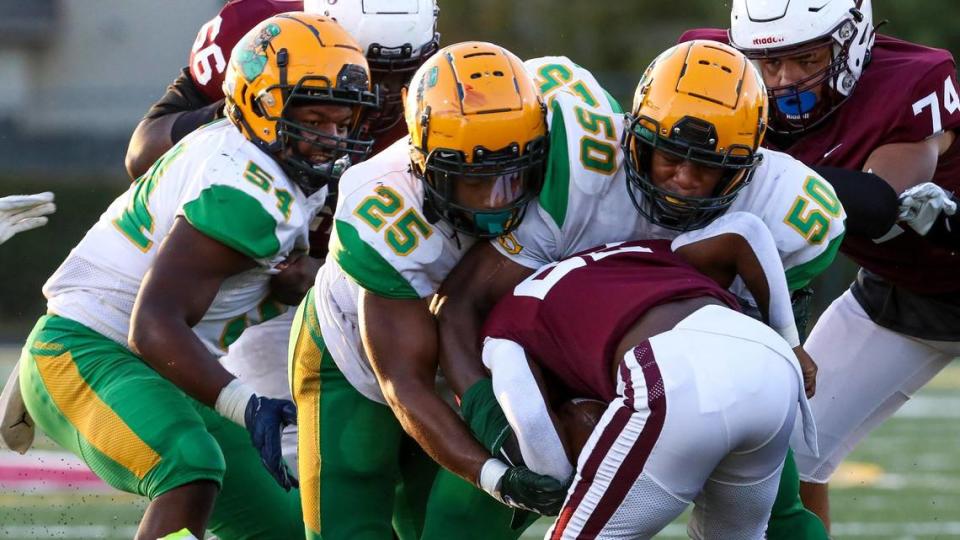 Tates Creek’s Tony Bell (22) is brought down by a group of Bryan Station Defenders including Keelan Adams (54), Jason Hocker (25) and Jahvon Frazier (50), during a 41-0 win at Tates Creek.