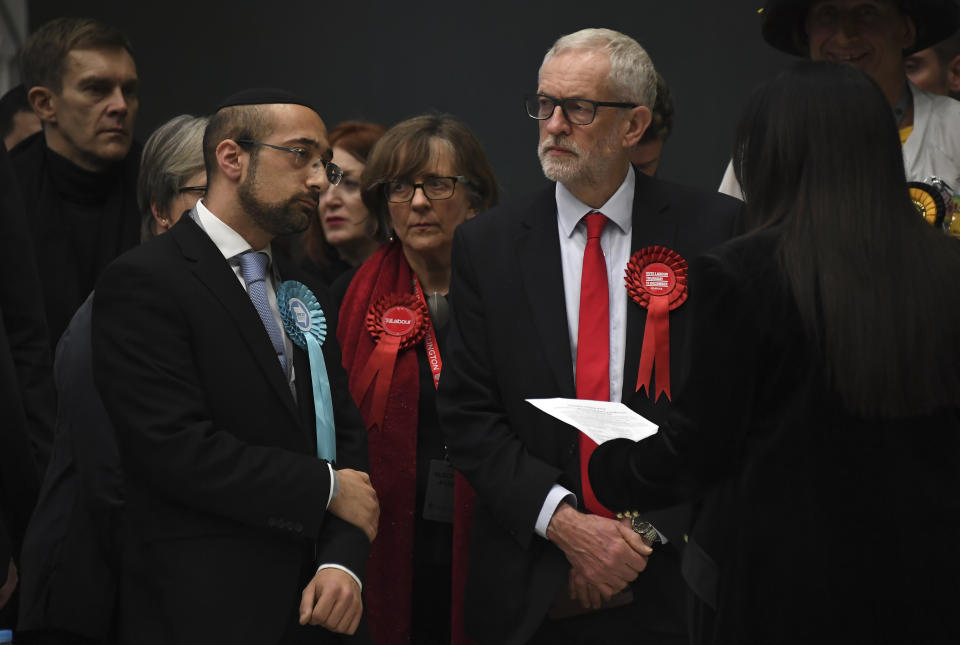 British opposition Labour Party leader Jeremy Corbyn, right, waits for the declaration of his seat in the 2019 general election in Islington, London, Friday, Dec. 13, 2019. The first handful of results to be declared in Britain's election are showing a surge in support for to the Conservatives in northern England seats where Labour has long been dominant. (AP Photo/Alberto Pezzali)