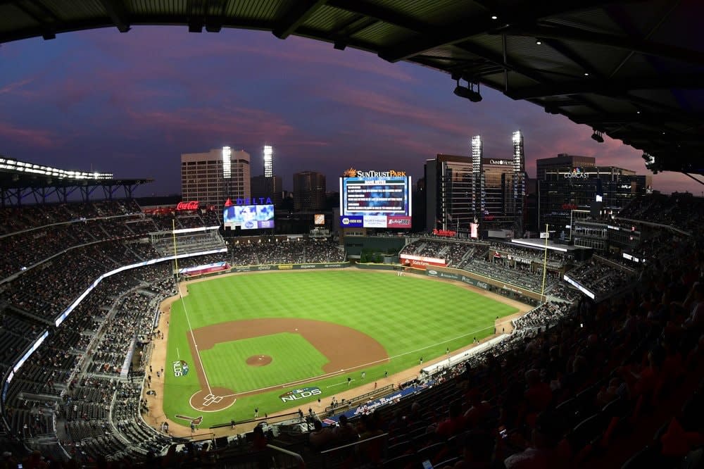 In this Oct. 7, 2018, file photo, ground crews prepare the field at Sun Trust Park, now known as Truist Park, ahead of Game 3 of MLB baseball’s National League Division Series between the Atlanta Braves and the Los Angeles Dodgers in Atlanta. (AP Photo/John Amis, File)