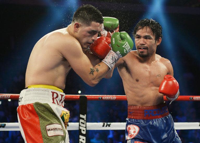 Manny Pacquiao punches Brandon Rios in their welterweight boxing bout in Macau on November 24, 2013