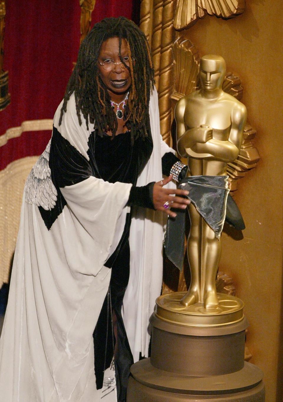 US actress and comedian Whoopi Goldberg jokes around with a Oscar statue during the 74th Academy Awards at the Kodak Theater in Hollywood 24 March 2002. (TIMOTHY A. CLARY/AFP/Getty Images)