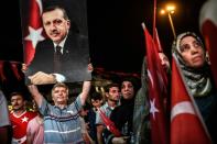 A man holds up a photo of Turkey's President Recep Tayyip Erdogan during a pro-Erdogan rally in Istanbul on July 22, 2016