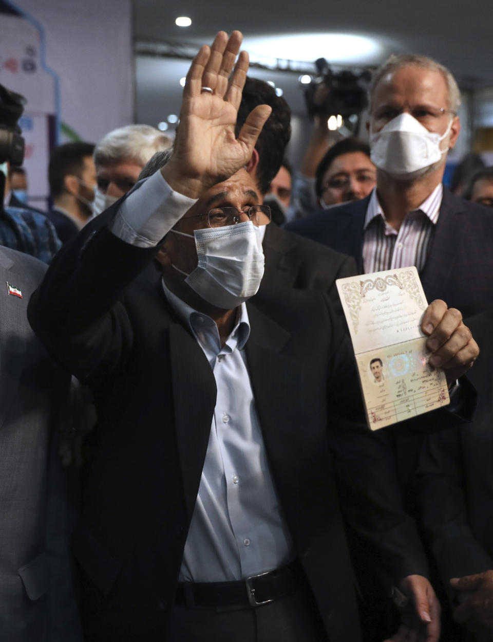 Former President Mahmoud Ahmadinejad waves as he shows his identification document while registering his name as a candidate for the June 18, presidential elections at elections headquarters of the Interior Ministry in Tehran, Iran, Wednesday, May 12, 2021. The country's former firebrand president will run again for office in upcoming elections in June. The Holocaust-denying Ahmadinejad has previously been banned from running for the presidency by Supreme Leader Ayatollah Ali Khamenei in 2017, although then, he registered anyway. (AP Photo/Vahid Salemi)