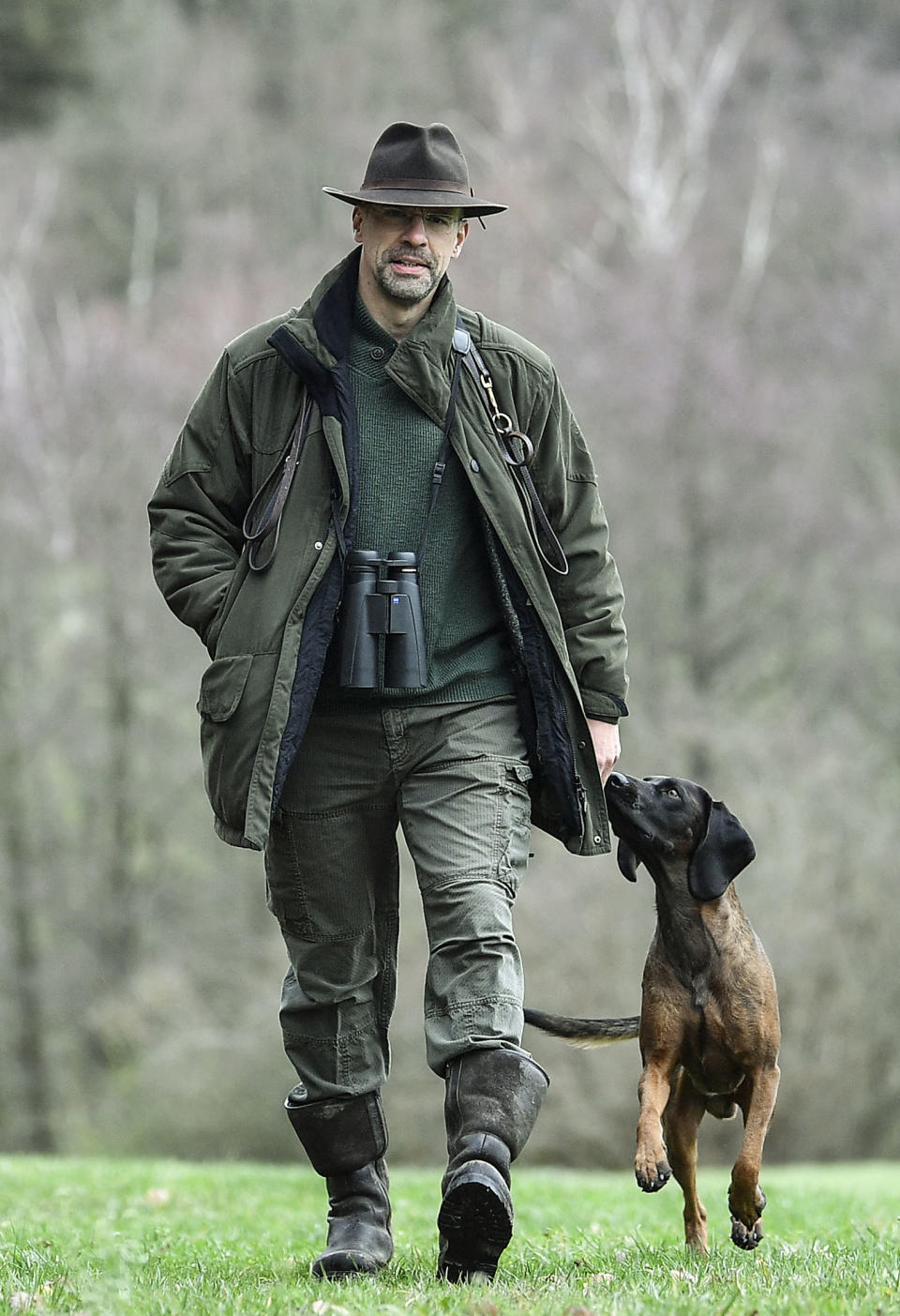 In this Dec. 7, 2018 photo Dirk Gratzel walks with his dog at his hunting ground in Stollberg, western Germany. Gratzel counts his carbon emissions. The software entrepreneur from Germany is among a growing number of people looking for ways to cut their personal greenhouse gas emissions from levels that scientists say are unsustainable if global warming is to be curbed. (AP Photo/Martin Meissner)