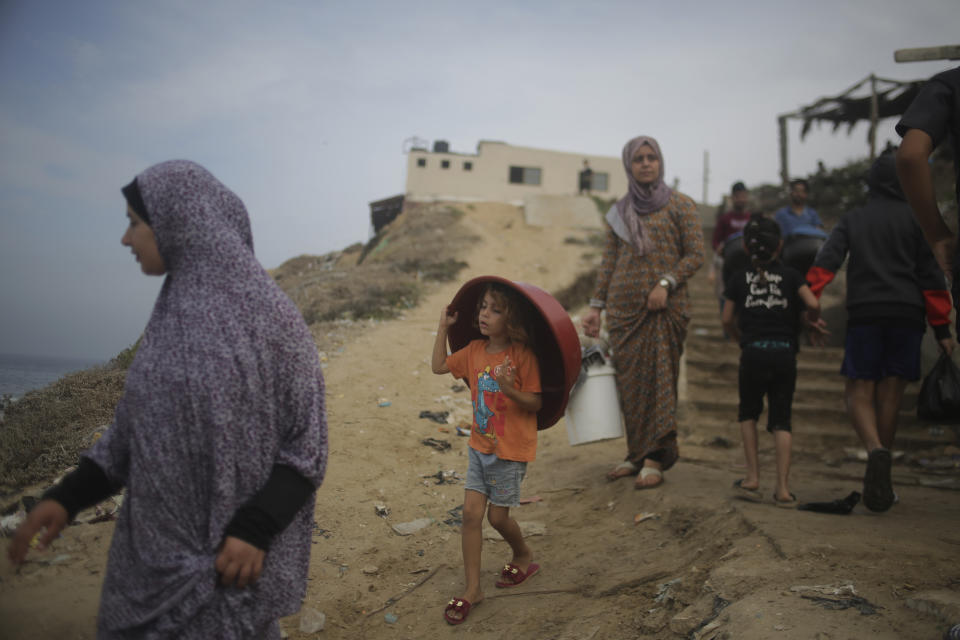 Palestinians resort to the sea water to bathe and clean their tools and clothes due the continuing water shortage in the Gaza Strip, on the beach of Deir al-Balah, Central Gaza Strip, Sunday, Oct. 29, 2023. (AP Photo/Mohammed Dahman)