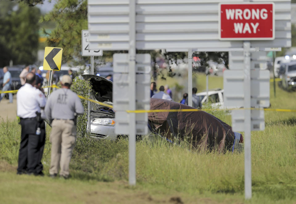 A Mandeville police car is covered with a tarp, after two Mandeville police officers were shot after a vehicle chase, one fatally, near the U.S. 190 and Louisiana Highway 22 exit in Mandeville, La., Friday, Sept. 20, 2019. Two suspects are in custody. (David Grunfeld/The Advocate via AP)