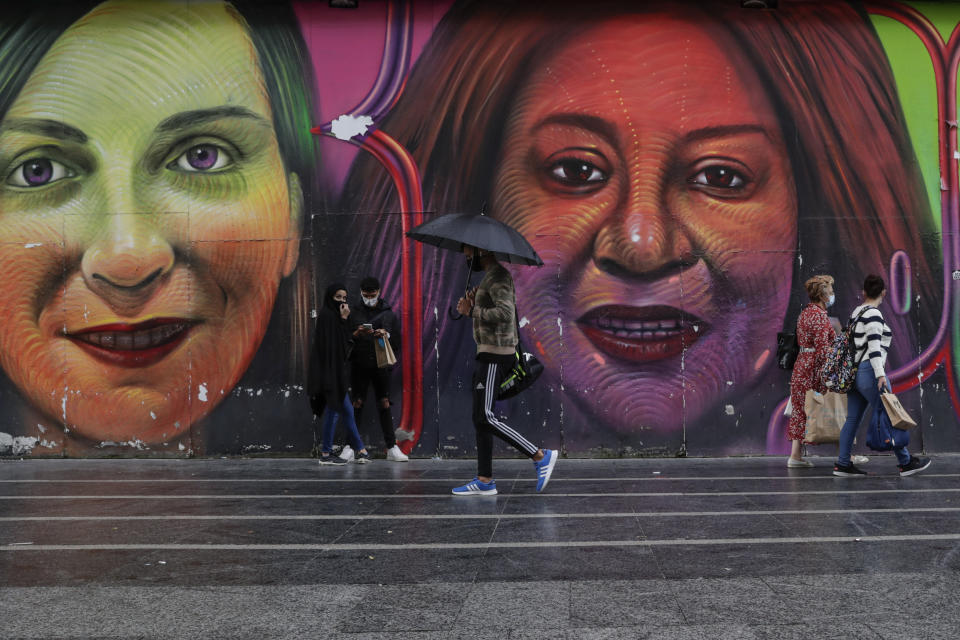 People wearing face masks to prevent the spread of coronavirus walk in downtown Madrid, Spain, Friday, Sept. 18, 2020. With more than 11,000 new daily coronavirus cases, the attention in Spain is focusing on its capital, where officials are mulling localized lockdowns and other measures to bring down the curve of contagion. (AP Photo/Manu Fernandez)