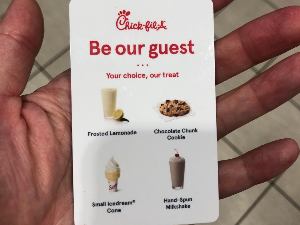 hand holding voucher for free treat at chick fil a