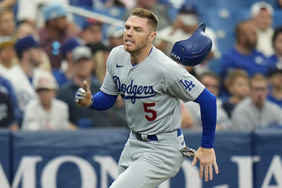 Los Angeles Dodgers' Freddie Freeman loses his helmet as he scores on an RBI single by J.D. Martinez off Tampa Bay Rays pitcher Josh Fleming during the third inning of a baseball game Sunday, May 28, 2023, in St. Petersburg, Fla. (AP Photo/Chris O'Meara)