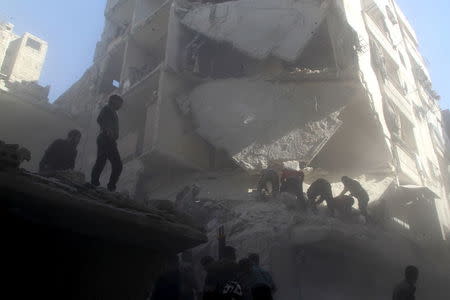 Residents and Civil Defense members search for survivors from under rubble of damaged buildings after an air strike on the rebel held al-Saliheen district in Aleppo, Syria, March 11, 2016. REUTERS/Abdalrhman Ismail