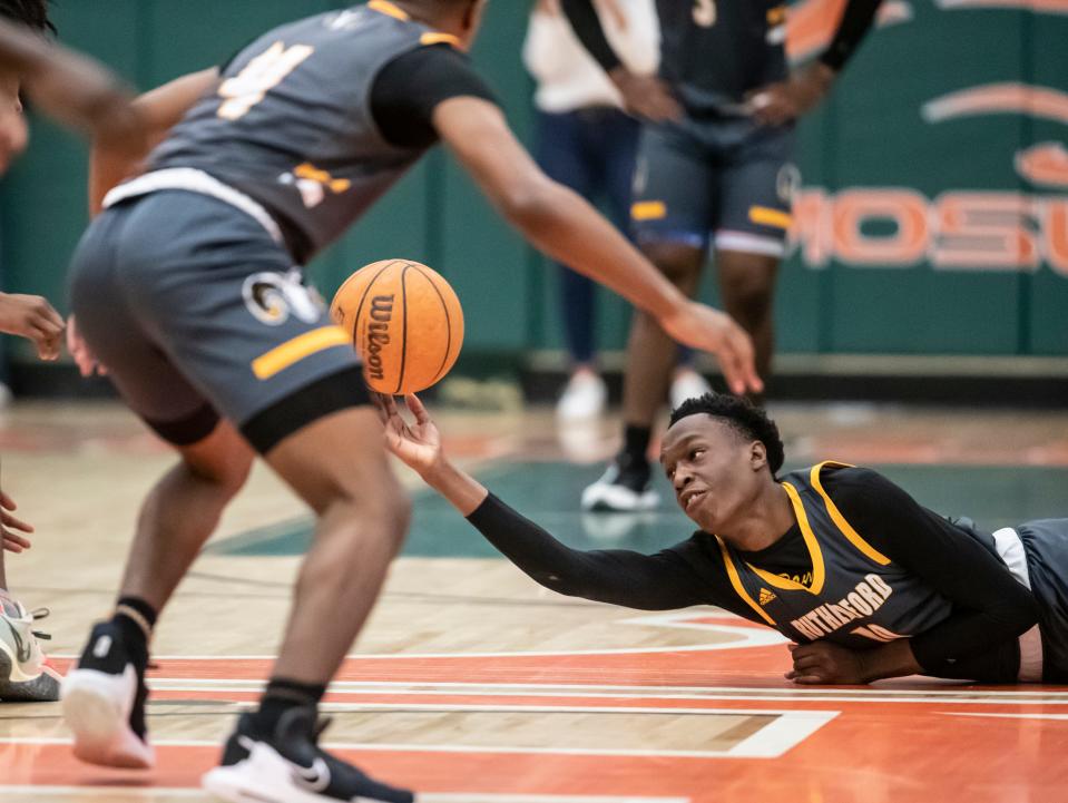 Rutherford junior Nakia Barnes tries to flip the ball to a teammate as he dives for a loose ball. Mosley hosted Rutherford in boys basketball Friday, January 21, 2022.