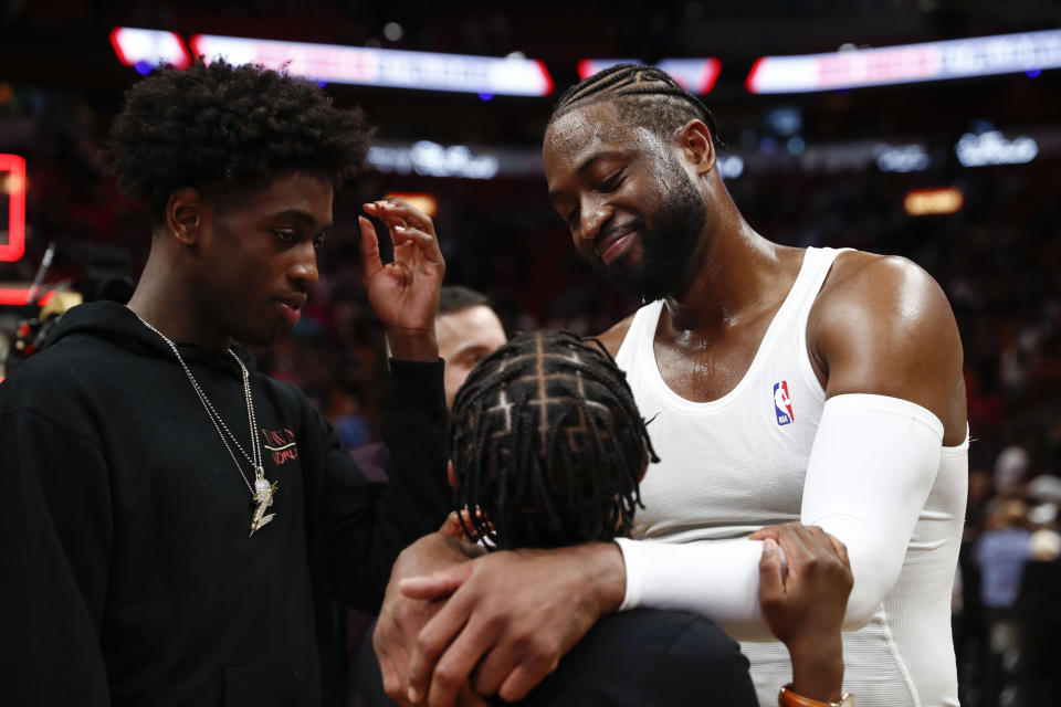 Miami Heat guard Dwyane Wade (3) celebrates with his sons, Zion Wade, right, and Zaire Wade, left after playing in his final NBA basketball game, against the Philadelphia 76ers, Tuesday, April 9, 2019, in Miami. (AP Photo/Brynn Anderson)