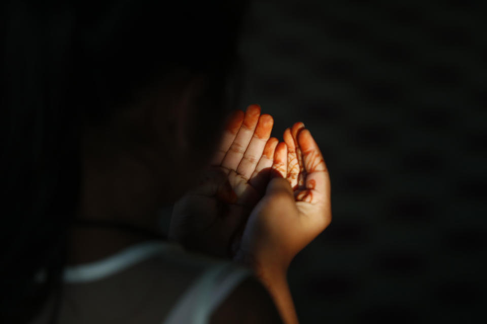 A Nepalese Muslim girl offers Eid al-Fitr prayers at a Mosque in Bhaktapur, Nepal, Monday, May 25, 2020. The holiday of Eid al-Fitr, the end of the fasting month of Ramadan, a usually joyous three-day celebration has been significantly toned down as coronavirus cases soar. (AP Photo/Niranjan Shrestha)