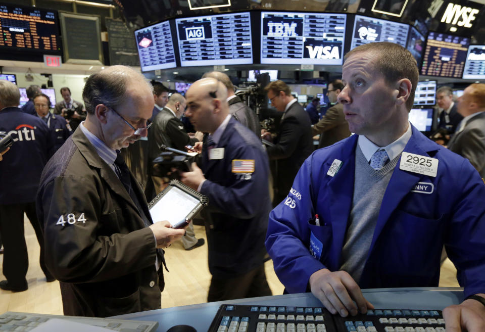 Specialist Robert Nelson, right, works on the floor of the New York Stock Exchange Thursday, April 24, 2014. Mixed earnings from a large number of U.S. companies left the stock market without direction early Thursday, despite positive results from a handful of names including Apple and Caterpillar. (AP Photo/Richard Drew)