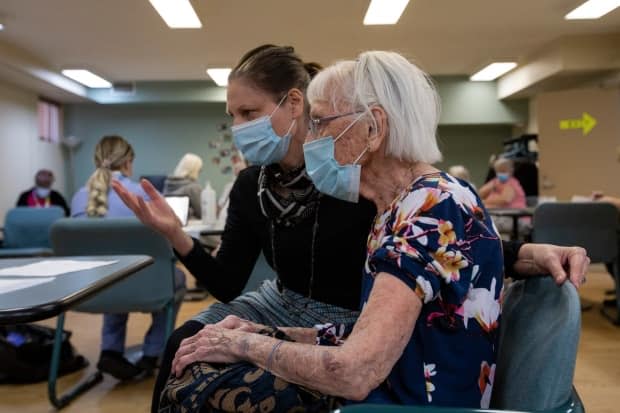 A resident who turns 99 in September waits with her daughter for her COVID-19 vaccination at the Canadian Martyrs Seniors Residence in Toronto. Both geriatrics and infectious disease experts say it's urgent to restore quality of life for long-term care residents after a year of devastating isolation. 