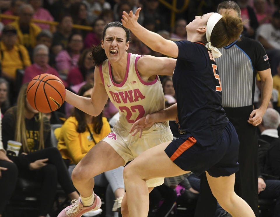 Iowa guard Caitlin Clark (22) drives past Illinois guard Gretchen Dolan (5) during the second half of an NCAA college basketball game, Sunday, Feb. 25, 2024, in Iowa City, Iowa. (AP Photo/Cliff Jette)