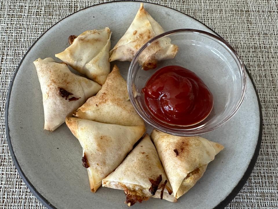 plate of air fried samosas with a side of sauce