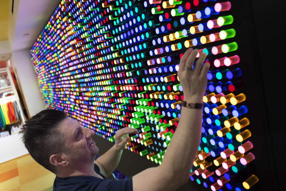 Adam Greenspan, founder and Chief Illumination Officer of LiteZilla, prepares his company's interactive wall in Story, Wednesday, April 10, 2019, at Macy's in New York. A year after buying startup Story, Macy's is bringing to life the retail concept to 36 stores in 15 states including its Manhattan flagship store. (AP Photo/Mark Lennihan)