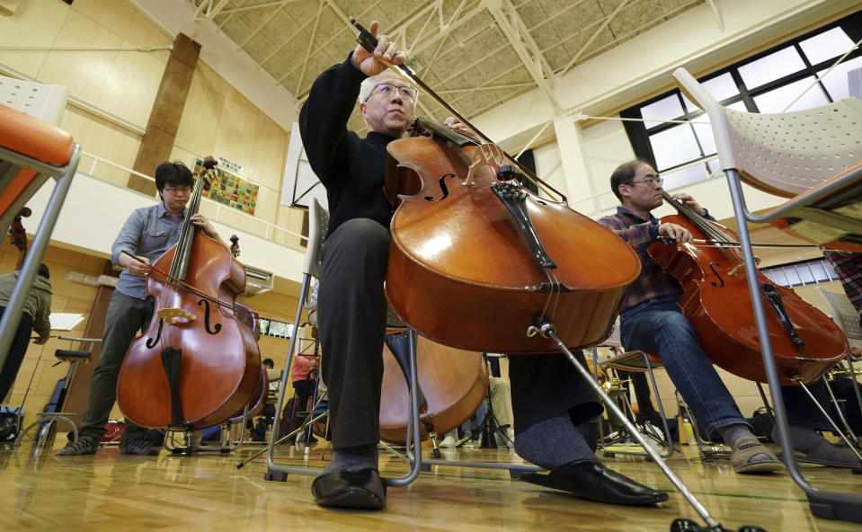 In this March 31, 2019, photo, Toshio Shiraishi, a longtime friend of Crown Prince Naruhito, plays his violoncello during a practice session of Shunyukai Symphony Orchestra in Tokyo. Shiraishi, a gray-haired banker who plays the cello, says the crown prince’s choice of instrument - viola - shows a lot about the kind of man he is.(AP Photo/Eugene Hoshiko
