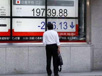 A man looks at an electronic board showing Japan's Nikkei average outside a brokerage at a business district in Tokyo, Japan August 9, 2017.   REUTERS/Kim Kyung-Hoon