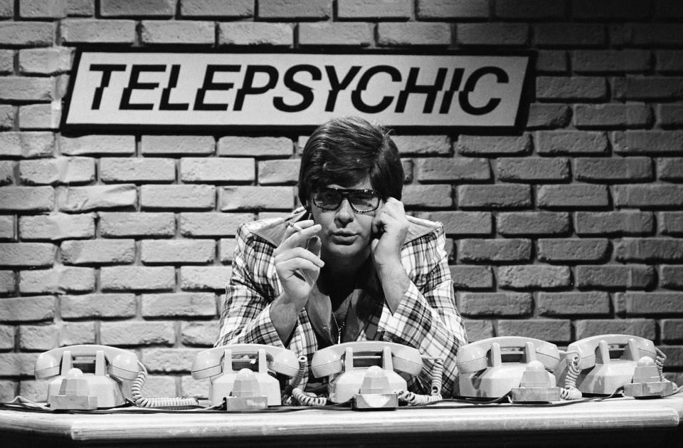 Dan Aykroyd on SNL with a "Telepsychic" sign behind him