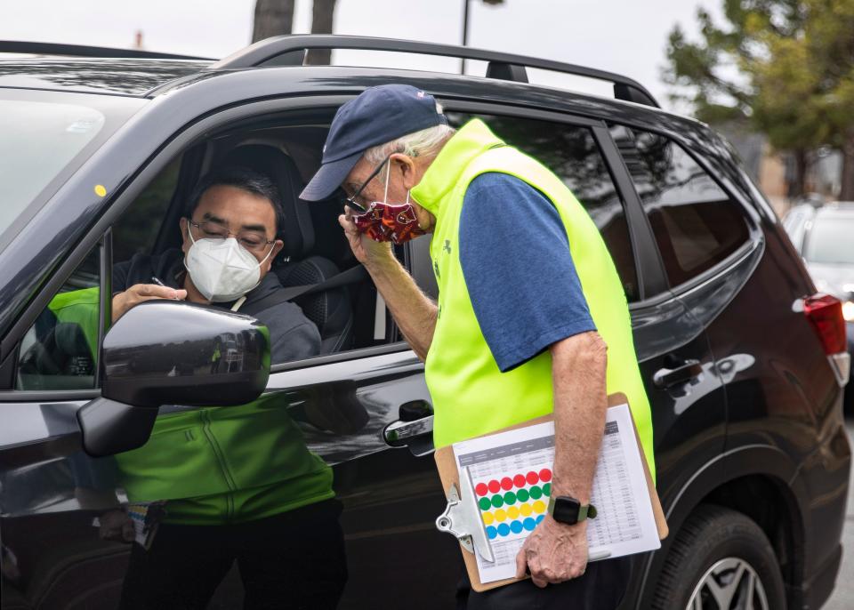 Bill Miles, 76, verifies drivers' appointments before they are given their COVID-19 vaccines at the Germantown Baptist site March 10 in Germantown, Tenn., an eastern suburb of Memphis in Shelby County.