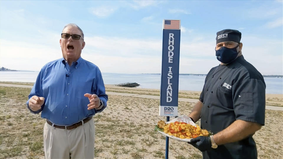 In this image from video, Joseph McNamara of Rhode Island speaks as chef John Bordieri holds a platter of squid during the state roll call vote on the second night of the Democratic National Convention on Aug. 18, 2020. Bordieri became known as the "calamari ninja" for his appearance during the video roll call. But he now says he's not heard from state or national leaders about a repeat performance at this summer's party's convention in Chicago. Bordieri also says he's backing former President Donald Trump, so they may not want him back. (Democratic National Convention via AP)