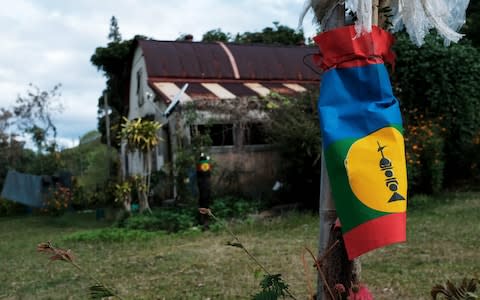 A flag from the FLNKS, Front de liberation nationale kanak socialiste (Kanak and Socialist National Liberation Front) flutters in a former settler's property of Poindimie - Credit: Theo Rouby / AFP