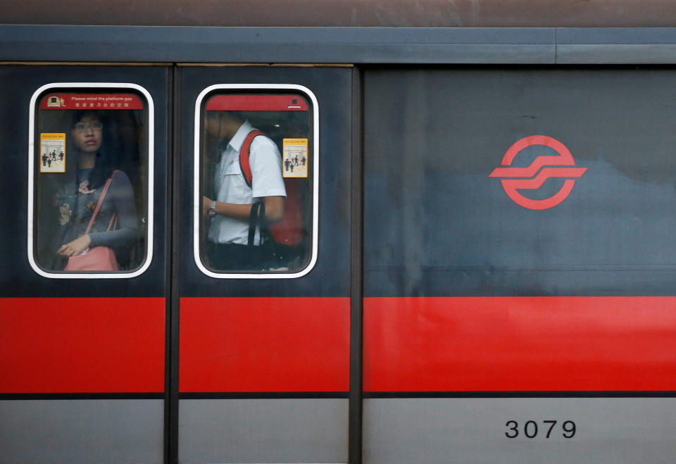 FILE PHOTO: People stand at the window of an SMRT train cabin in Singapore July 19, 2016. REUTERS/Edgar Su/File Photo