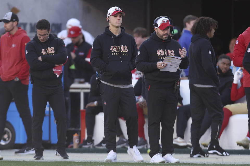 San Francisco 49ers quarterback Brock Purdy, middle, watches from the sideline during the first half of an NFL football game against the Los Angeles Rams in Santa Clara, Calif., Sunday, Jan. 7, 2024. (AP Photo/Jed Jacobsohn)