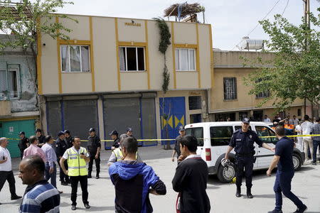 Police secure the scene as locals watch after two rockets hit the Turkish town of Kilis near the Syrian border, Turkey, April 24, 2016. REUTERS/Umit Bektas