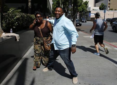 Rapper Brandon Duncan, also known as Tiny Doo, gets a hug from Tina Cook as he leaves court during a lunch- hour break in the motion to dismiss charges against him in San Diego, California March 16, 2015 REUTERS/Mike Blake
