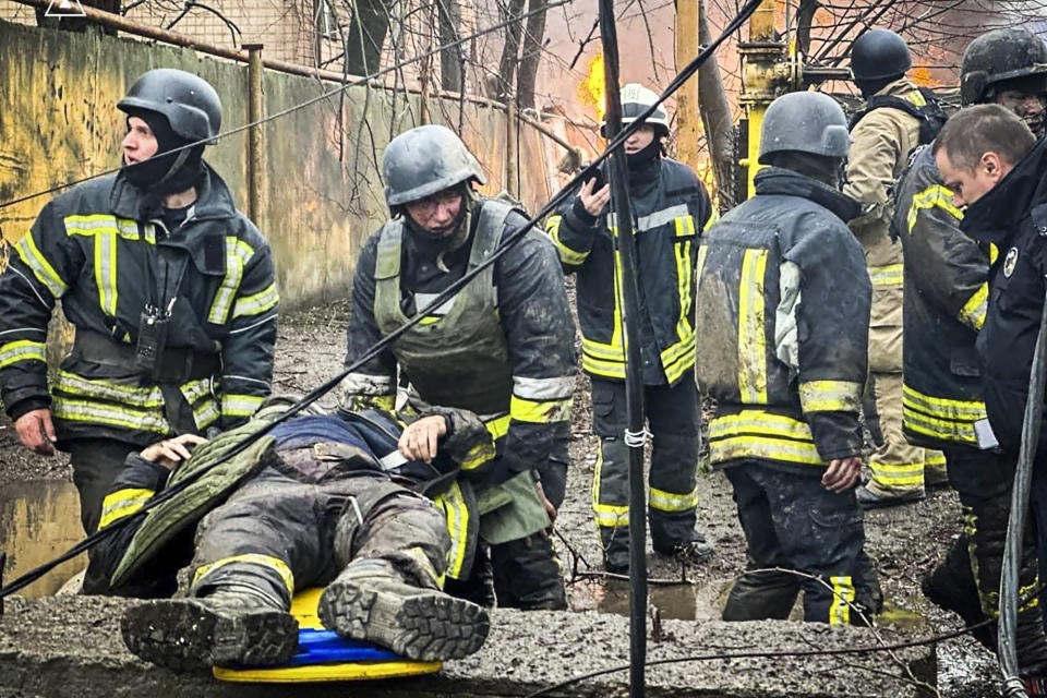 In this photo provided by the Ukrainian Emergency Service, emergency services help their comrade injured during a Russian attack in Odesa, Ukraine, Friday, March 15, 2024. A Russian missile strike on Odesa in southern Ukraine on Friday killed at least 14 people and injured 46 others, local officials said. (Ukrainian Emergency Service via AP)